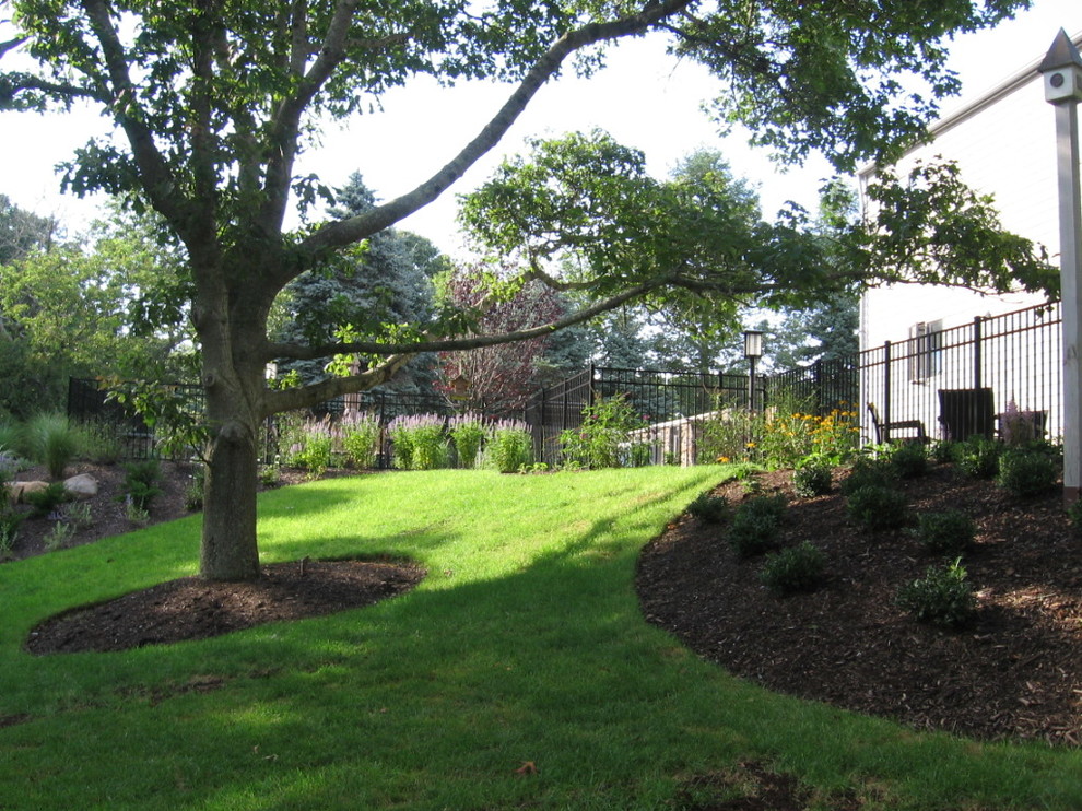 Photo of a traditional sloped garden in New York with a garden path and natural stone pavers.