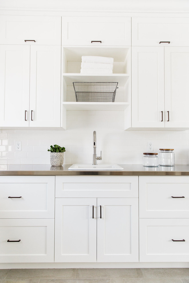 Design ideas for a transitional laundry room in Salt Lake City with a drop-in sink, flat-panel cabinets, white cabinets, stainless steel benchtops and white walls.