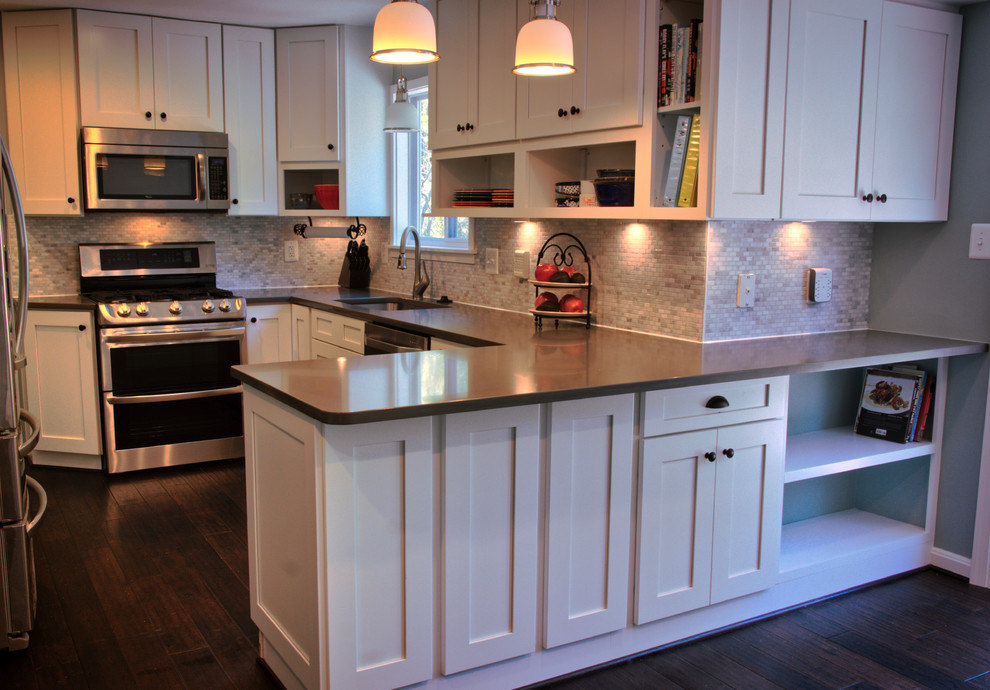 Inspiration for a mid-sized transitional u-shaped dark wood floor and brown floor kitchen remodel in DC Metro with an undermount sink, shaker cabinets, white cabinets, quartz countertops, gray backsplash, matchstick tile backsplash, stainless steel appliances and a peninsula