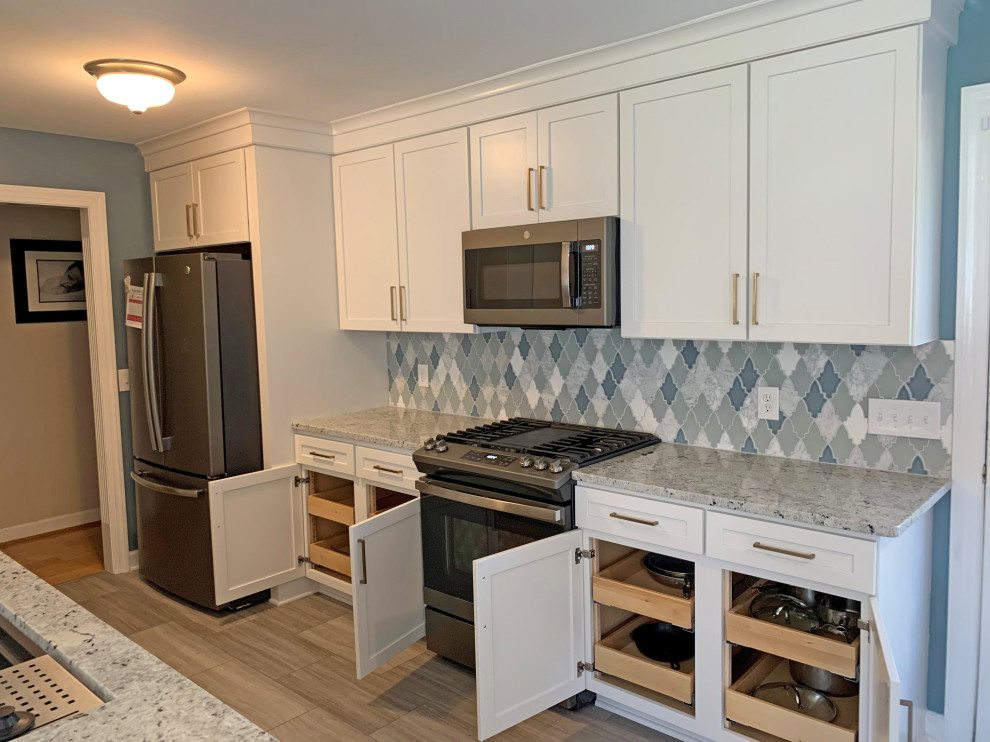 This is an example of a medium sized classic galley kitchen/diner in Nashville with a single-bowl sink, shaker cabinets, white cabinets, granite worktops, green splashback, mosaic tiled splashback, stainless steel appliances, vinyl flooring, a breakfast bar, grey floors and grey worktops.