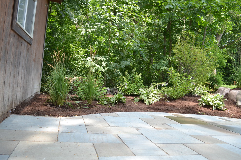 Photo of a mid-sized country backyard garden in Milwaukee with natural stone pavers.