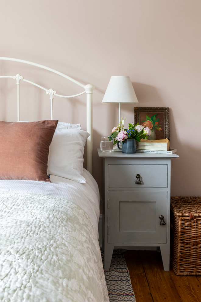 Traditional guest bedroom in London with pink walls.
