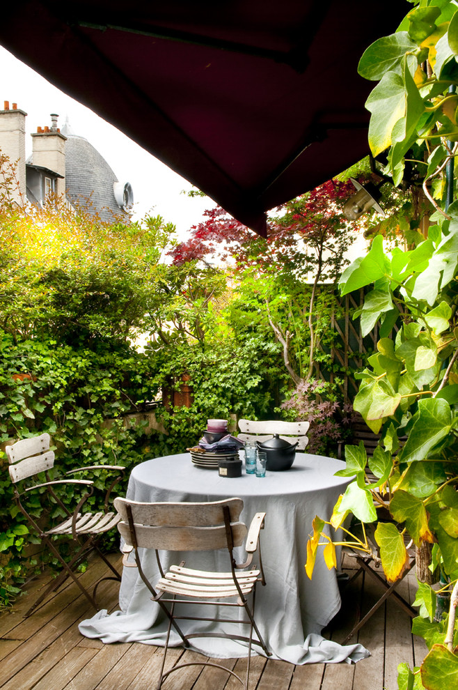 This is an example of an eclectic deck in Paris with a vertical garden and an awning.