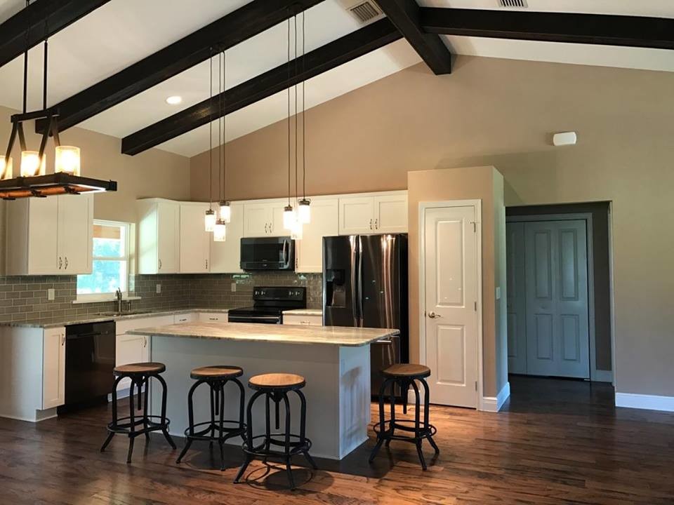 Mid-sized transitional l-shaped dark wood floor and brown floor open concept kitchen photo in Orlando with an undermount sink, recessed-panel cabinets, white cabinets, granite countertops, gray backsplash, subway tile backsplash, stainless steel appliances and an island