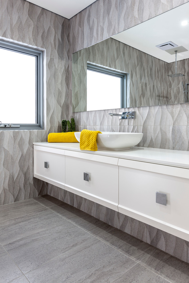 Inspiration for a large contemporary master bathroom in Perth with recessed-panel cabinets, porcelain tile, porcelain floors, a vessel sink, solid surface benchtops, white cabinets, gray tile and grey walls.