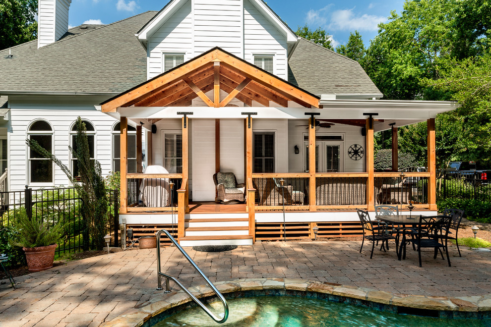 This is an example of a large arts and crafts backyard deck in Atlanta with a roof extension.