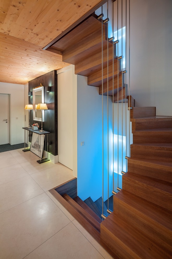 Mid-sized modern painted wood curved staircase in Other with painted wood risers and metal railing.
