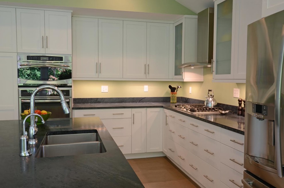 Inspiration for a mid-sized transitional u-shaped open plan kitchen in Baltimore with an undermount sink, shaker cabinets, white cabinets, limestone benchtops, stainless steel appliances, with island, ceramic floors and brown floor.