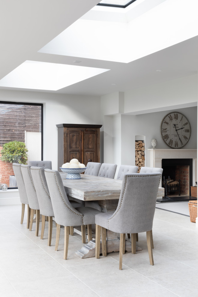 Photo of a large traditional open plan dining in Surrey with limestone floors, grey floor and exposed beam.