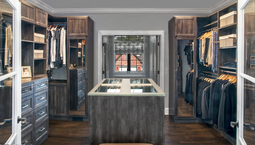 Mid-sized transitional gender-neutral walk-in wardrobe in Chicago with recessed-panel cabinets, distressed cabinets, dark hardwood floors and brown floor.