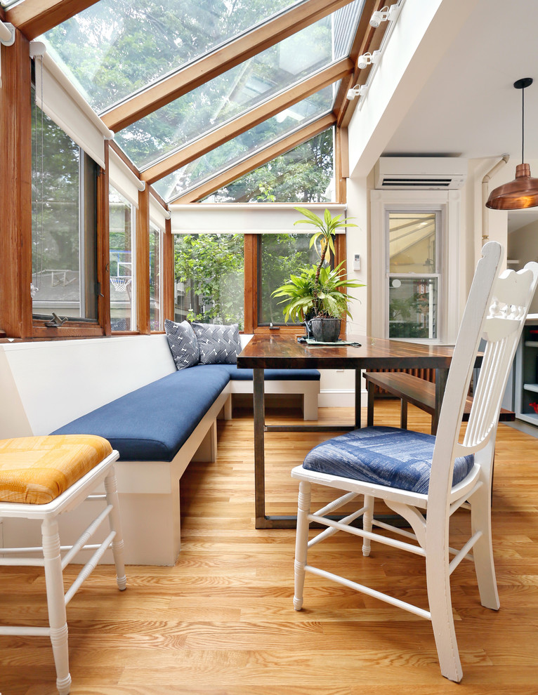 This is an example of a mid-sized transitional sunroom in Boston with medium hardwood floors and a glass ceiling.