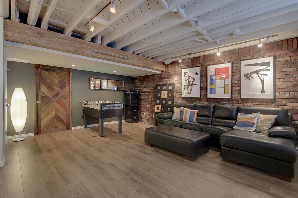 Photo of an industrial basement in Edmonton with a game room, grey walls, vinyl flooring and brick walls.
