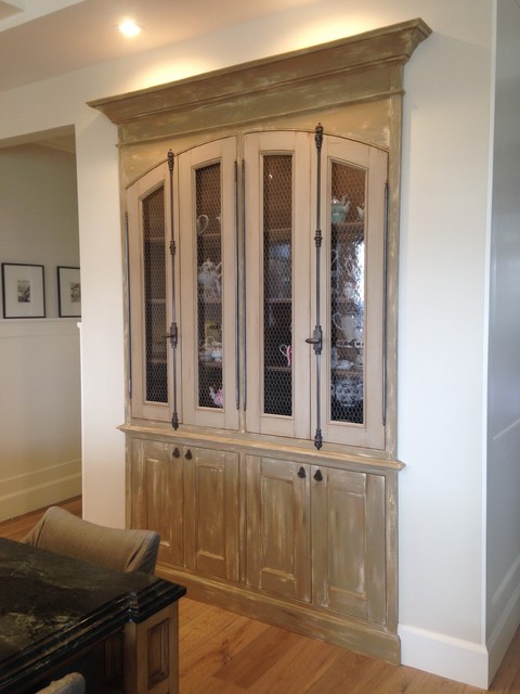 Example of a mid-sized arts and crafts eat-in kitchen design in Orange County with glass-front cabinets and brown cabinets