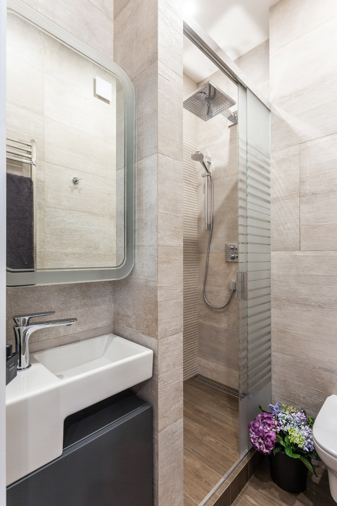Design ideas for a small contemporary 3/4 bathroom in Saint Petersburg with beige cabinets, a drop-in tub, a wall-mount toilet, beige tile, porcelain tile, beige walls, porcelain floors, a wall-mount sink, flat-panel cabinets and brown floor.