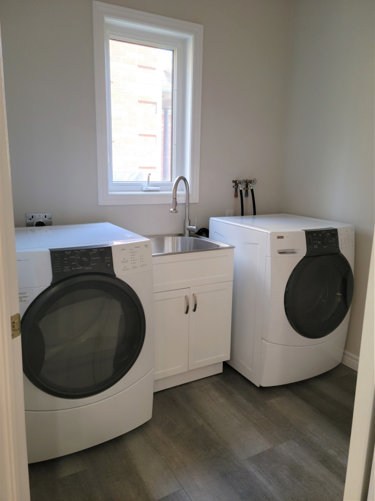 Example of a mid-sized transitional u-shaped vinyl floor eat-in kitchen design with an undermount sink, recessed-panel cabinets, blue cabinets, quartzite countertops, white backsplash, porcelain backsplash, black appliances, a peninsula and black countertops