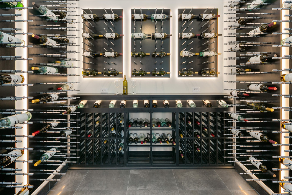 This is an example of a large contemporary wine cellar in Seattle with grey floor and display racks.