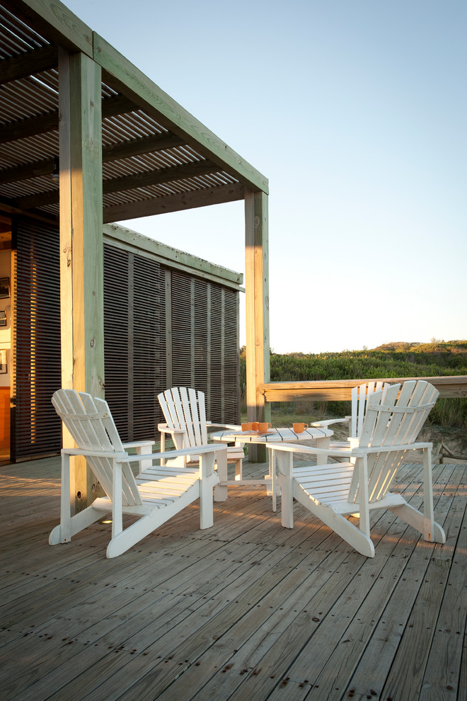 Photo of a beach style deck in Other with a pergola.