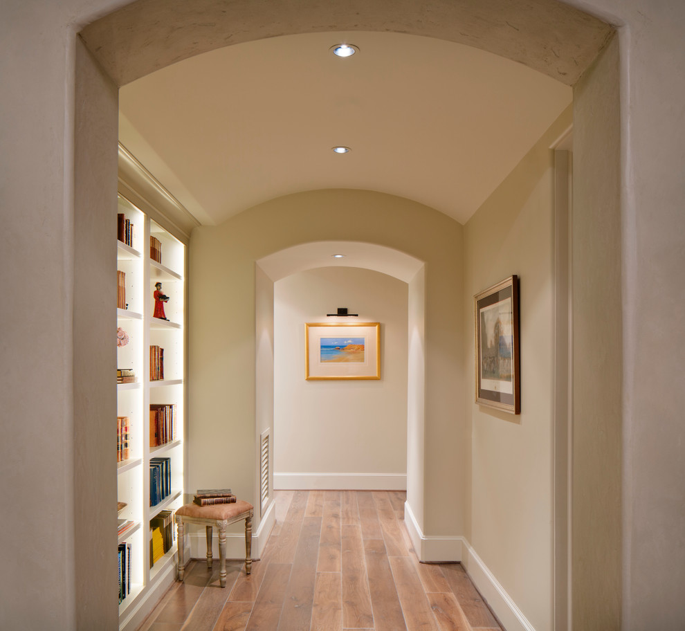 This is an example of a mid-sized contemporary hallway in Houston with beige walls and light hardwood floors.