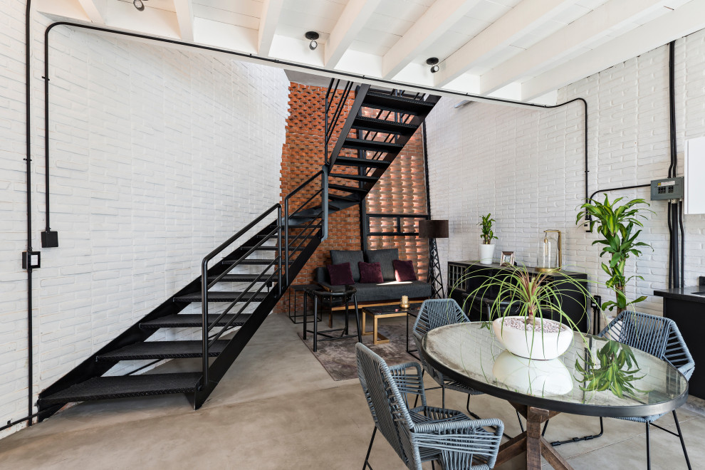 Стильный дизайн: маленькая гостиная-столовая в стиле рустика с белыми стенами, кирпичным полом, серым полом, балками на потолке и кирпичными стенами для на участке и в саду - последний тренд