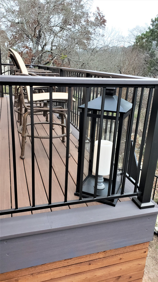 Example of a large mountain style backyard second story metal railing deck design in Austin with a roof extension