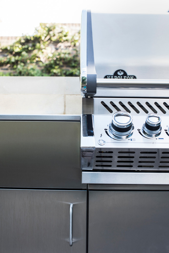 This is an example of an eclectic back patio in London with an outdoor kitchen and no cover.