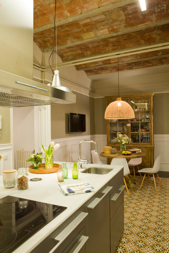 Large single-wall separate kitchen in Barcelona with a single-bowl sink, distressed cabinets, metallic splashback, stainless steel appliances, with island and multi-coloured floor.