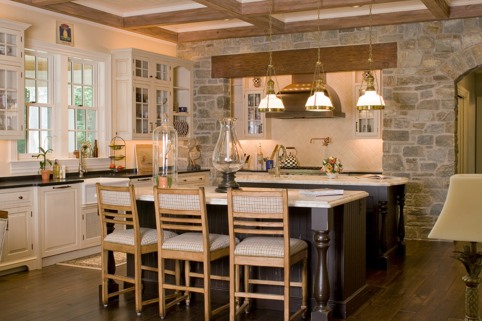 Inspiration for a traditional l-shaped kitchen in St Louis with a farmhouse sink, raised-panel cabinets, white cabinets, beige splashback, dark hardwood floors, multiple islands, brown floor and white benchtop.
