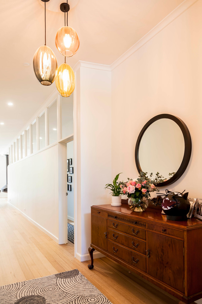 Mid-sized midcentury hallway in Melbourne with white walls, light hardwood floors and brown floor.