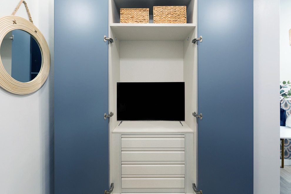 Immagine di piccoli armadi e cabine armadio moderni con nessun'anta, ante blu, parquet chiaro e pavimento grigio