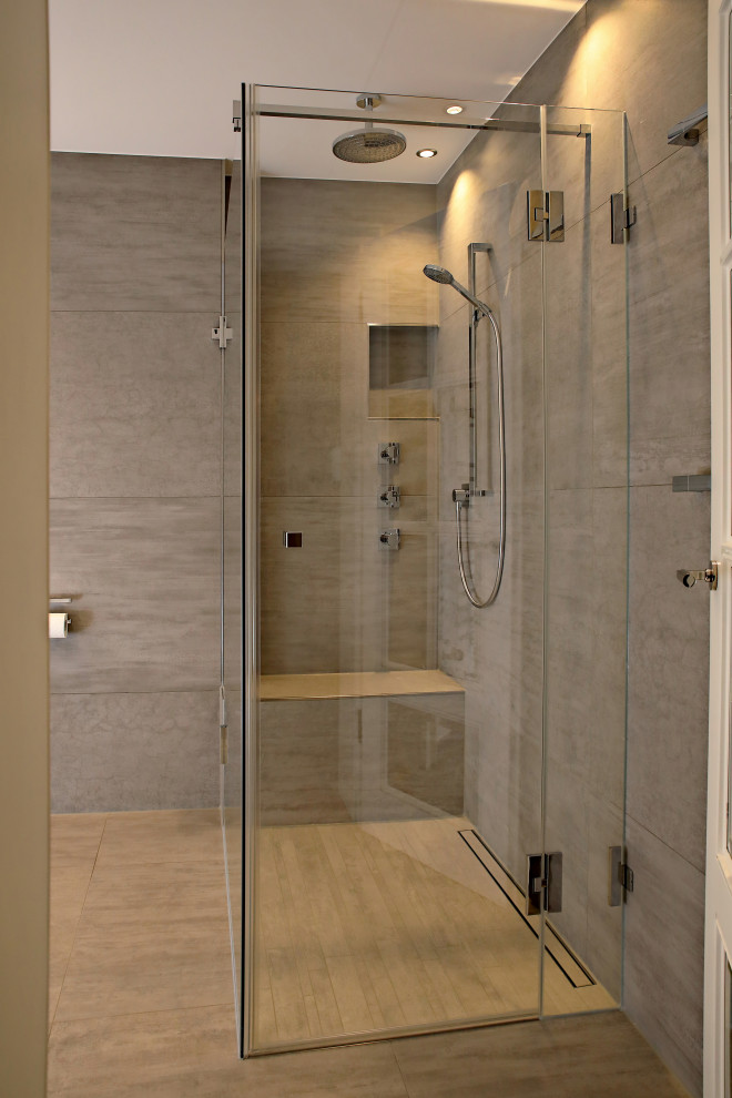 Großes Modernes Duschbad mit bodengleicher Dusche, Wandtoilette mit Spülkasten, grauen Fliesen, weißer Wandfarbe, Wandwaschbecken, grauem Boden und Falttür-Duschabtrennung in München