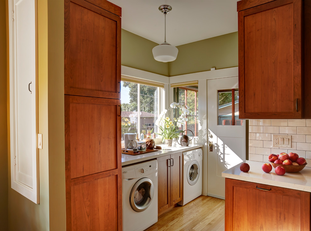 This is an example of a mid-sized arts and crafts l-shaped separate kitchen in San Francisco with an undermount sink, shaker cabinets, medium wood cabinets, quartz benchtops, white splashback, ceramic splashback, white appliances and medium hardwood floors.