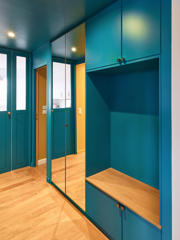 Imagen de recibidores y pasillos actuales de tamaño medio con paredes azules, suelo de madera en tonos medios y suelo marrón