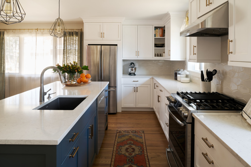 Mid-sized 1950s l-shaped light wood floor and brown floor eat-in kitchen photo in Denver with an undermount sink, shaker cabinets, white cabinets, quartz countertops, gray backsplash, ceramic backsplash, stainless steel appliances, an island and gray countertops
