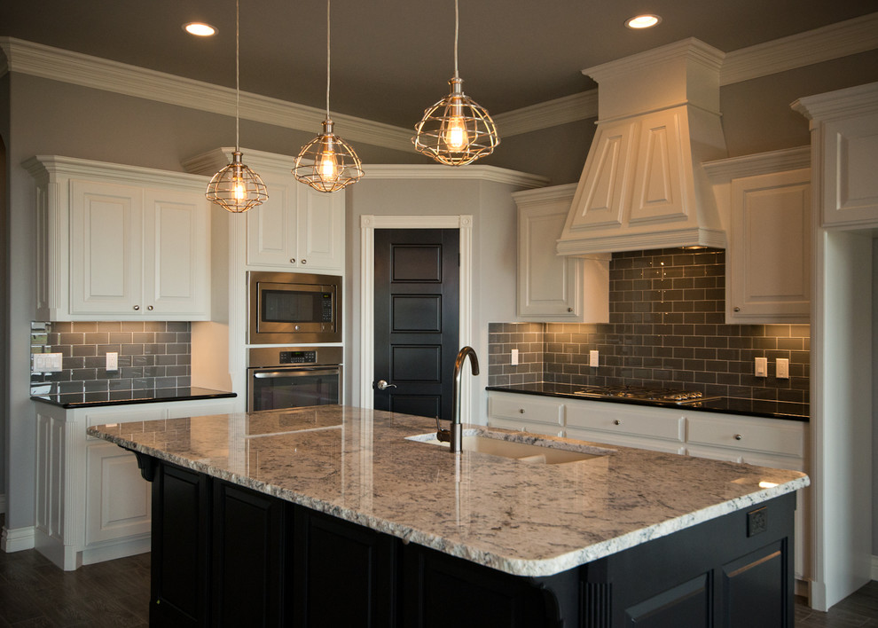 Open concept kitchen - mid-sized transitional l-shaped medium tone wood floor open concept kitchen idea in Oklahoma City with a double-bowl sink, raised-panel cabinets, white cabinets, granite countertops, gray backsplash, ceramic backsplash, stainless steel appliances and an island