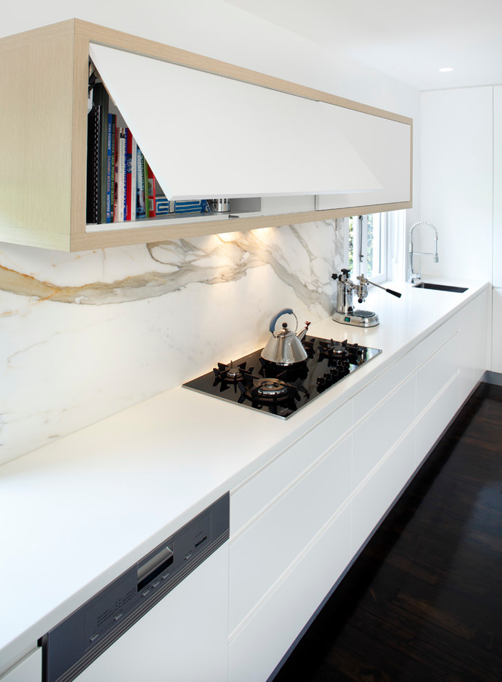 Design ideas for a modern single-wall eat-in kitchen in Sydney with a drop-in sink, flat-panel cabinets, white cabinets, solid surface benchtops, stainless steel appliances, white splashback and marble splashback.