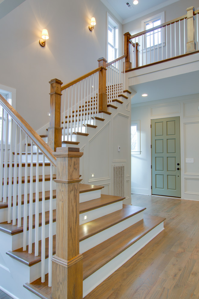 Photo of a large traditional wood l-shaped staircase in Nashville with painted wood risers.