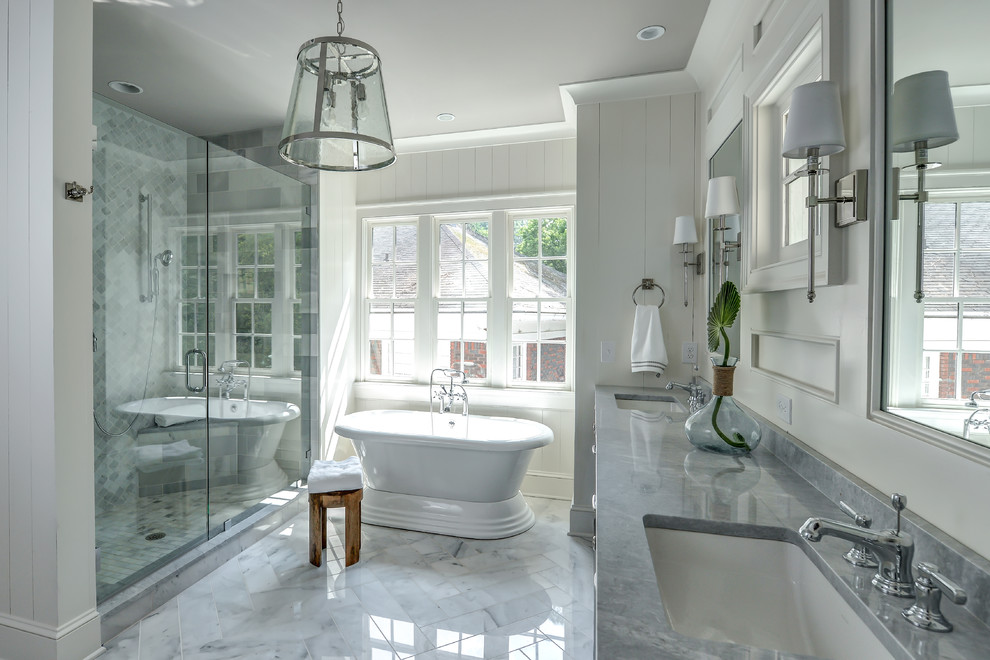 Photo of a transitional bathroom in Los Angeles with a freestanding tub, an alcove shower, gray tile, white walls, an undermount sink, white floor, a hinged shower door and grey benchtops.