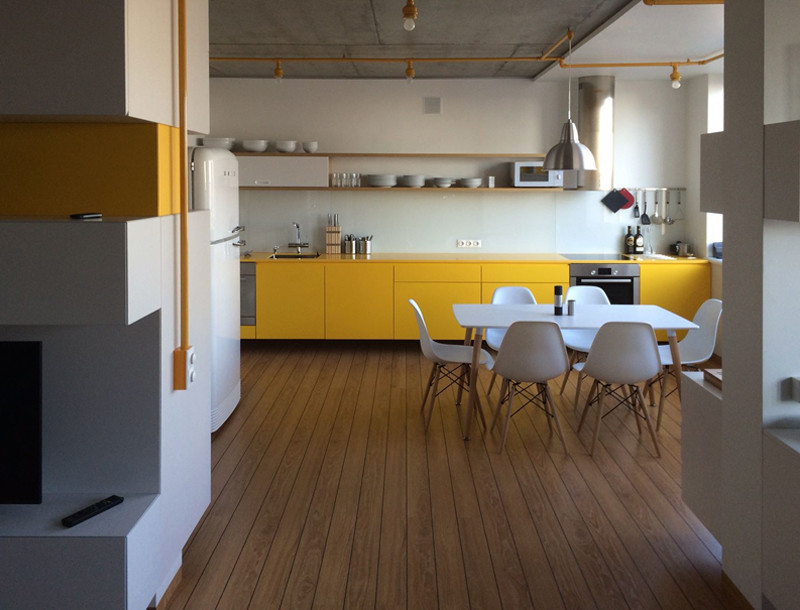 Offene, Einzeilige, Mittelgroße Moderne Küche mit flächenbündigen Schrankfronten, gelben Schränken, Küchenrückwand in Beige, Laminat, Kücheninsel und gelber Arbeitsplatte in Berlin