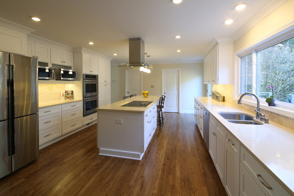 Design ideas for a large modern kitchen in Atlanta with a drop-in sink, shaker cabinets, white cabinets, quartz benchtops, black splashback, stone tile splashback, stainless steel appliances, medium hardwood floors and with island.
