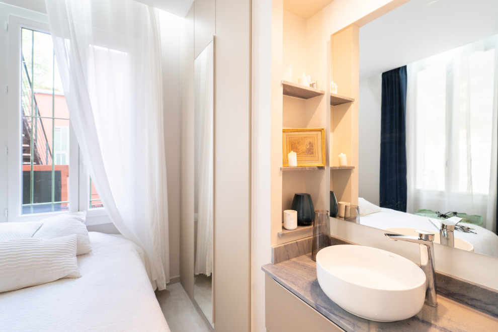 Cette image montre une petite salle de bain beige et blanche design avec un mur beige, un sol en carrelage de céramique et meuble-lavabo encastré.
