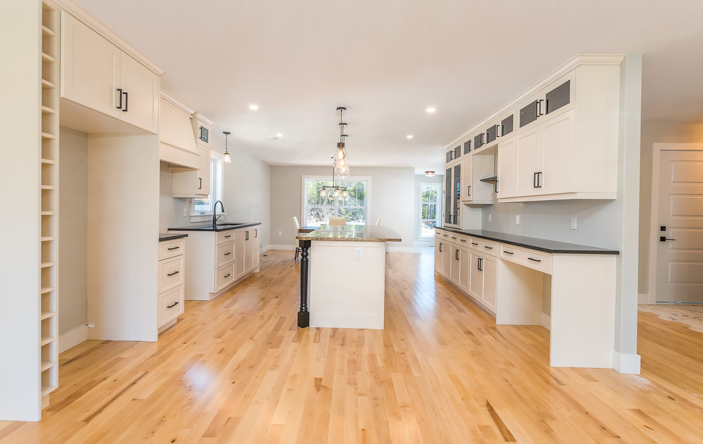 Example of a large transitional light wood floor and beige floor eat-in kitchen design