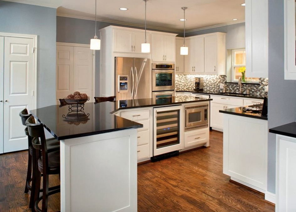 Inspiration for a mid-sized transitional l-shaped medium tone wood floor and brown floor enclosed kitchen remodel in Vancouver with an undermount sink, shaker cabinets, white cabinets, solid surface countertops, multicolored backsplash, mosaic tile backsplash, stainless steel appliances and an island