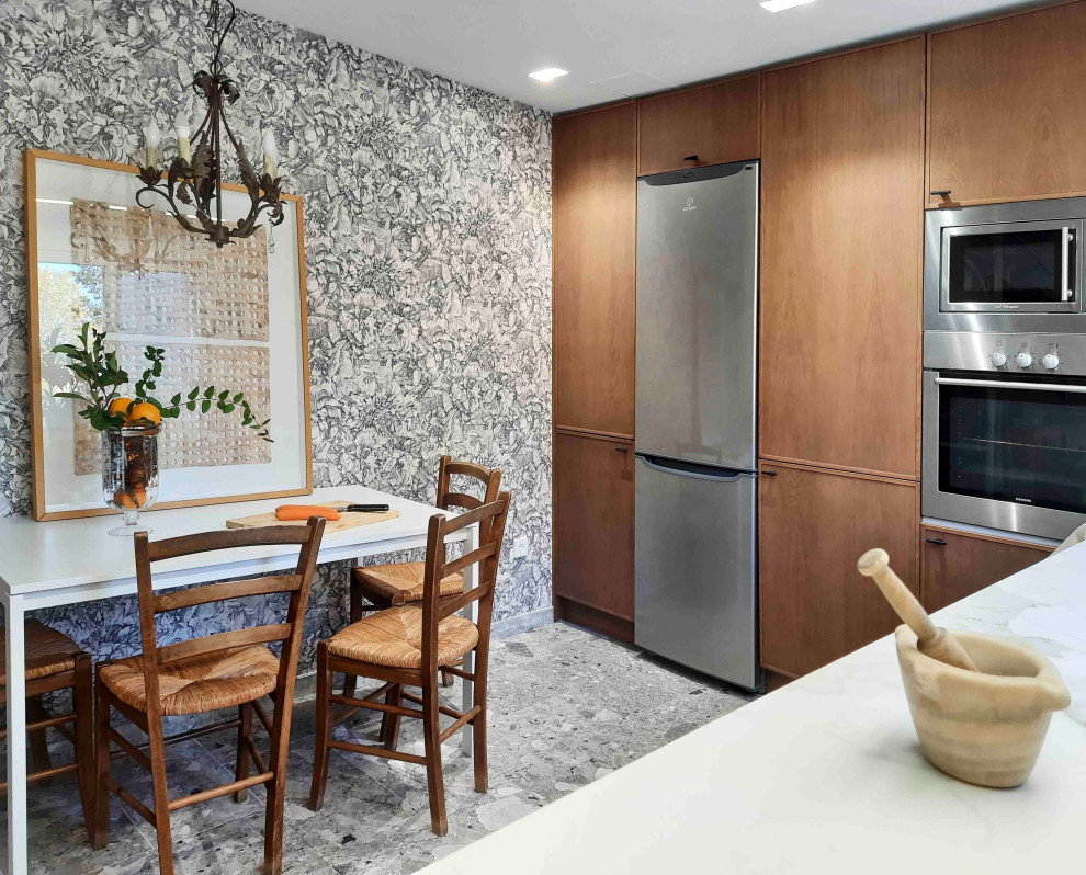 マドリードにある北欧スタイルのおしゃれなキッチン (中間色木目調キャビネット、白いキッチンパネル、シルバーの調理設備、磁器タイルの床、グレーの床、白いキッチンカウンター) の写真