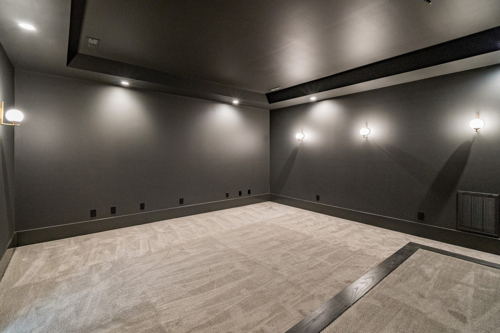 This is an example of a transitional home theatre in Raleigh with black walls, carpet and beige floor.