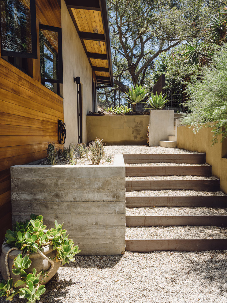 Photo of a mid-sized backyard partial sun garden in Los Angeles with gravel.