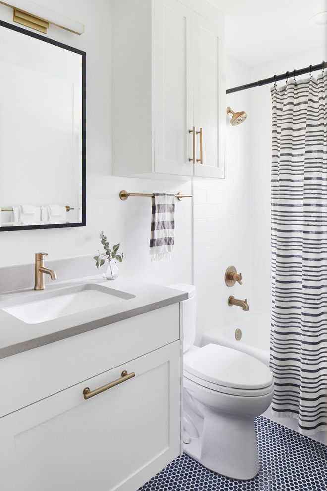 Inspiration for a small modern kids bathroom in Austin with shaker cabinets, white cabinets, an alcove tub, a shower/bathtub combo, a one-piece toilet, ceramic tile, white walls, mosaic tile floors, an undermount sink, engineered quartz benchtops, blue floor, a shower curtain and grey benchtops.