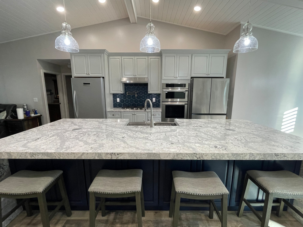 Medium sized classic galley kitchen/diner in Miami with a belfast sink, raised-panel cabinets, engineered stone countertops, blue splashback, ceramic splashback, stainless steel appliances, an island, multicoloured worktops, a vaulted ceiling and blue cabinets.