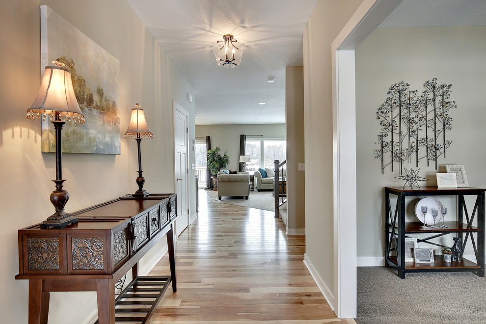 Photo of a large traditional entry hall in Minneapolis with grey walls, light hardwood floors and a single front door.