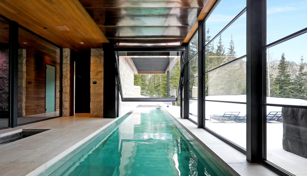 Design ideas for an expansive modern indoor rectangular lap pool in Salt Lake City with natural stone pavers.