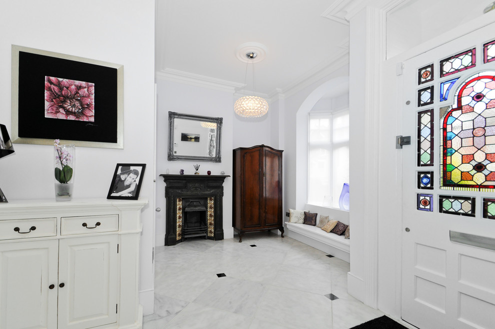 This is an example of a traditional foyer in London with white walls and a white front door.